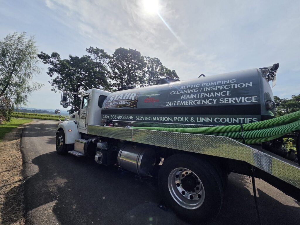 Stahr Septic Service green pump truck pulling up to a residential property at the start of a septic service call in Salem, Oregon — prompt, reliable service in Marion County and surrounding areas.