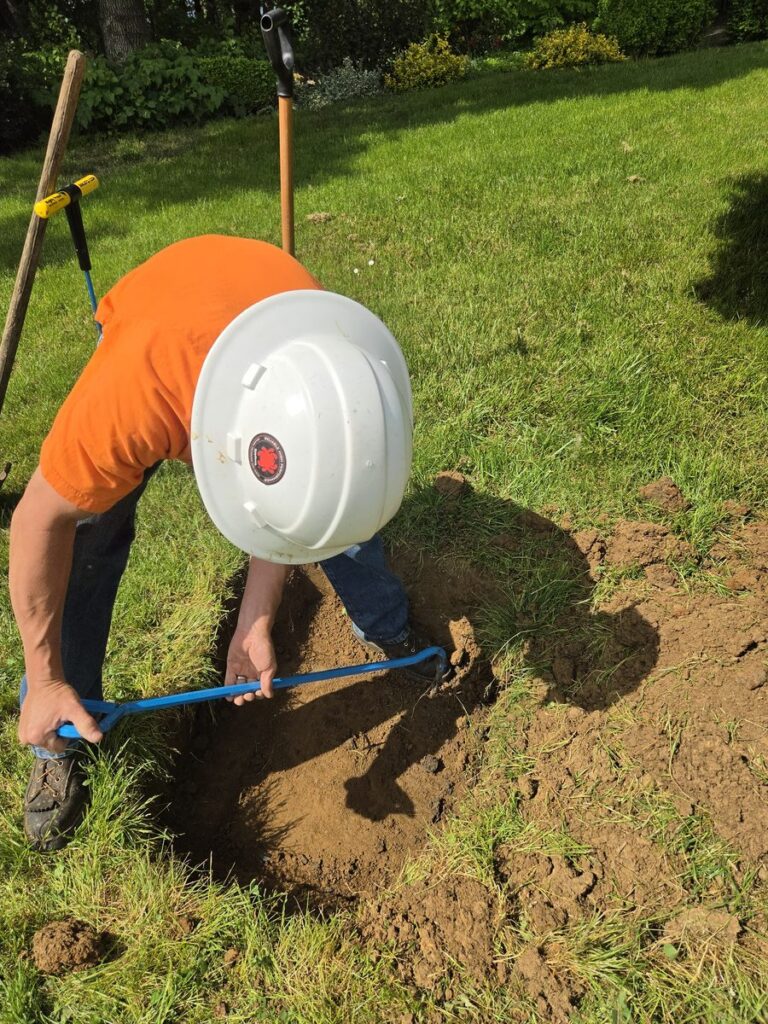 Andrew Stahr of Stahr Septic Service closely inspecting a residential septic system during a service call in Salem, Oregon — detailed, honest assessment included with every pump-out.