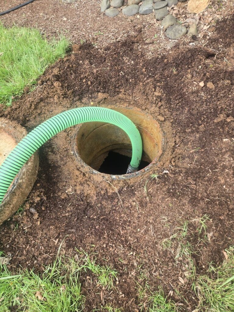 Exposed circular septic tank opening in a residential yard — Stahr Septic Service locates and uncovers tanks throughout Marion, Linn, and Polk counties in Oregon's Willamette Valley.